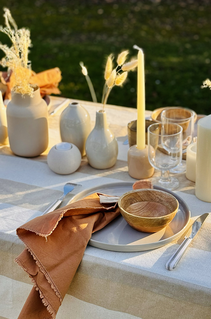 Table en plein air, linge crème, assiette en céramique, bol en bois, serviette terracotta et fleurs séchées - Table by At Home With Soni.
